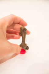 Top-down view of the bronze monkey weight showing the intricate texture along its spine.
