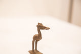 Side profile of a vintage Ashanti bronze pelican gold weight with handmade texture.