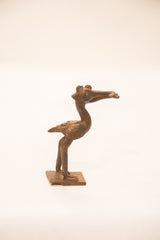 Profile of a vintage African bronze pelican sculpture with etched details on its wing and body.