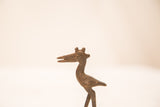 Textured head and open beak of a vintage bronze pelican with a dark iron-like patina.