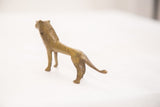Rear perspective of the vintage bronze lion with elongated body and green patina.