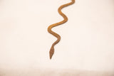 Aged, handmade texture of a vintage Lobi iron snake artifact.