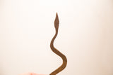 Detail of the vintage handmade iron snake, highlighting its rustic texture and unique curved form.