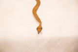 Hand-forged vintage iron snake, showing its unique pointed head and rich rust patina.