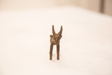 Frontal view of a vintage bronze impala ram, highlighting its face and textured horns.