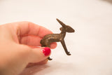 Vintage bronze impala gold weight held in hand to demonstrate its scale.