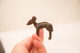 A small vintage bronze ewe sculpture held in profile to show its dark patina.