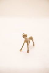 Angled view of the vintage cheetah bronze sculpture, showing its simple, stylized form.