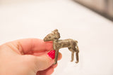 A small vintage bronze ram sculpture held in hand to show scale and patina.