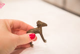 Small bronze ram sculpture with a dark iron-like patina held in hand for scale.