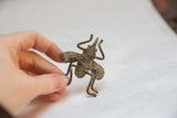The vintage bronze fly sculpture held to show its three-dimensional form and texture.