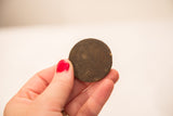 Underside of a vintage bronze African gold weight with a dark, textured patina.