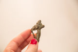 Handmade Ashanti bronze gold weight held to show its small scale and textured patina.