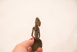 The small, handmade Ashanti bronze gold weight held in hand to show its collectible scale.