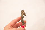 Profile of a handmade Ashanti bronze gold weight with textured details and a blue-green patina.