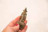 The back of a handmade Ashanti bronze spoon showing the figure's form and aged patina.
