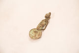 The sculptural female form and oxidized bronze texture of a vintage Ashanti gold weight.