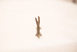 Vintage rabbit bronze sculpture, top-down view of slender body and ears with blue-green patina.