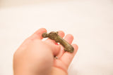 Hand-held bronze hippo gold weight with a distinctive time-softened patina.