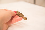 Vintage bronze snake sculpture with shiny patina, held in hand.