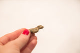 Side view of the small bronze snake showing its rustic, handmade texture and details.