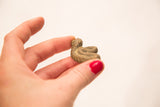 Close view of the vintage bronze snake's face and coiled body held for scale.