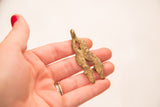 Hand-cast bronze double headed snake showing the piece's scale and rustic finish.