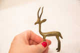Handmade bronze gazelle sculpture held, showcasing its compact size and green patina.