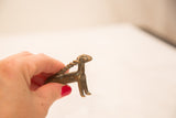 Antique bronze antelope sculpture featuring a twisted, broken horn and shiny patina.