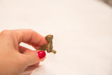 Small antique bronze meerkat sculpture highlighting its scale and expressive pose.