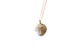 Vintage African head pendant with a textured, blue-green patina on a delicate chain.
