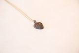 Handmade African head pendant with a dark patina, shown from a three-quarter angle.