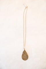 Full length view of a vintage bronze necklace with a geometric teardrop pendant.