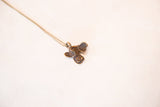 Angled view of a handmade bronze fish pendant showcasing its rich, textured patina.
