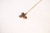 Angled view of the handmade bronze fish pendant showing its textured fins and patina.