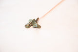 Detailed view of the handmade African fish pendant with blue oxidized patina.