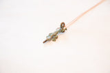 Angled view of the handmade crocodile pendant's unique oxidized green patina.