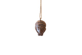 Vintage handmade African pendant necklace designed as a person's face with a dark bronze patina.