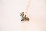 Vintage African rooster pendant showing the handmade, textured detail of its oxidized patina.