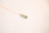 Vintage African pineapple pendant showing green patina and delicate chain.