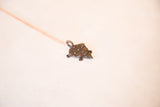 Dark bronze turtle pendant with textured shell and aged patina.