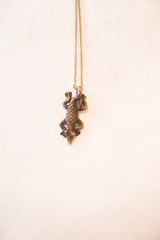 Vintage African lizard pendant with a textured body and dark bronze patina.