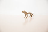 Profile of a vintage bronze lion sculpture highlighting its rustic handmade charm and texture.