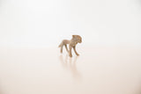 Side view of a vintage mini bronze lion showing its textured, aged patina.