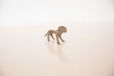 Angled view of the small bronze lion highlighting its rustic handmade texture.