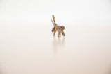 Rear view of a vintage bronze elephant showing its rustic texture and raised trunk.