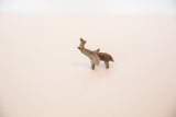Profile view of a handmade mini bronze elephant with a rustic, aged patina.
