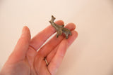 A hand holding the small vintage bronze elephant to demonstrate its miniature scale.
