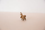 Rear view of a handmade mini bronze elephant with a rusty, textured patina.