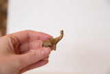 Vintage mini bronze elephant held in hand to show its small scale and texture.